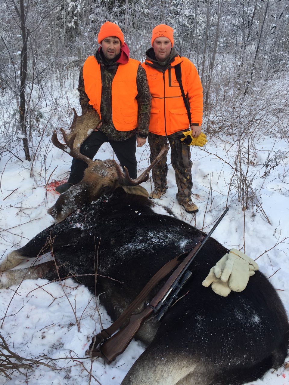 A photo of Roben Ogden and his son Jordan posing with a large bull moose.
